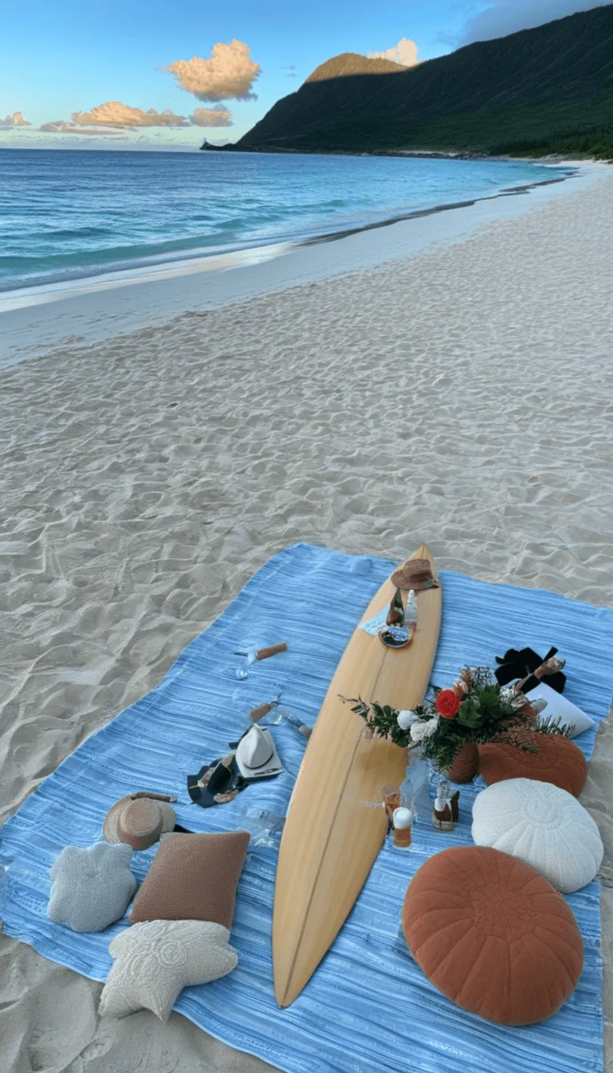 Beach picnic setup with surfboard and cushions