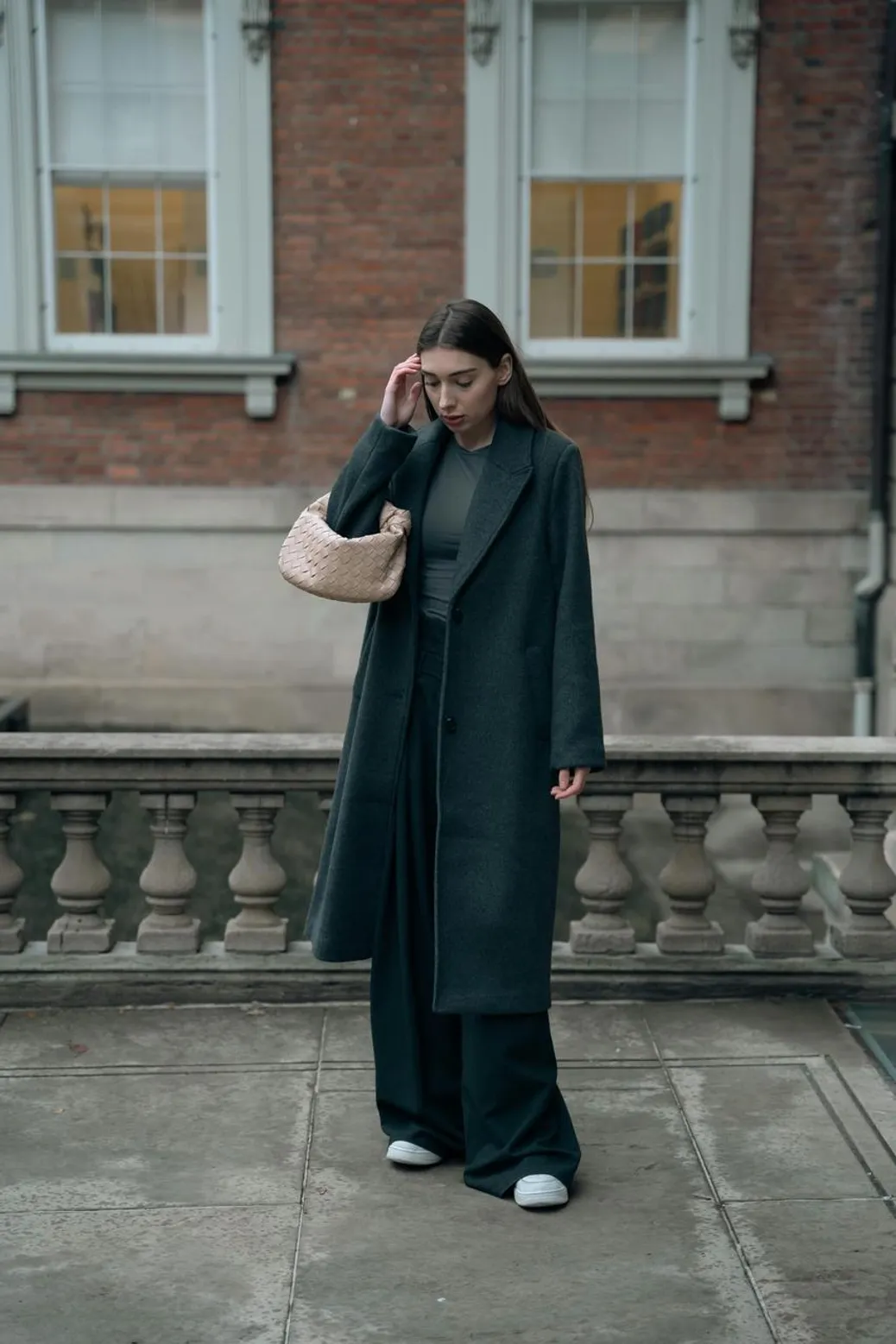 Woman wearing emerald velvet pants styled for daytime fashion with a rich, cozy vibe