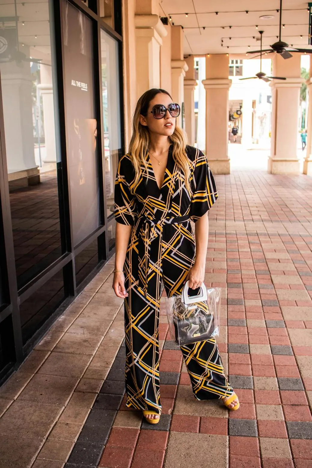 Patterned jumpsuit styled with minimal accessories and sneakers for an effortless look