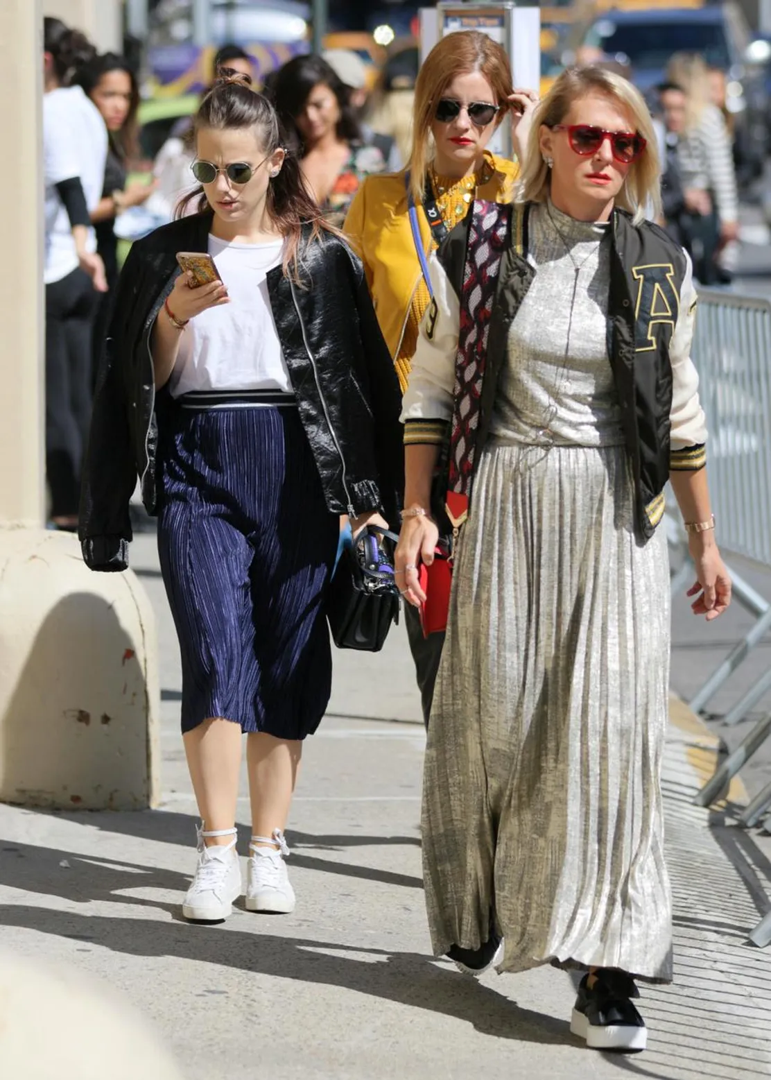 Varsity jacket with bold patches, paired with pleated skirts for a trendy look
