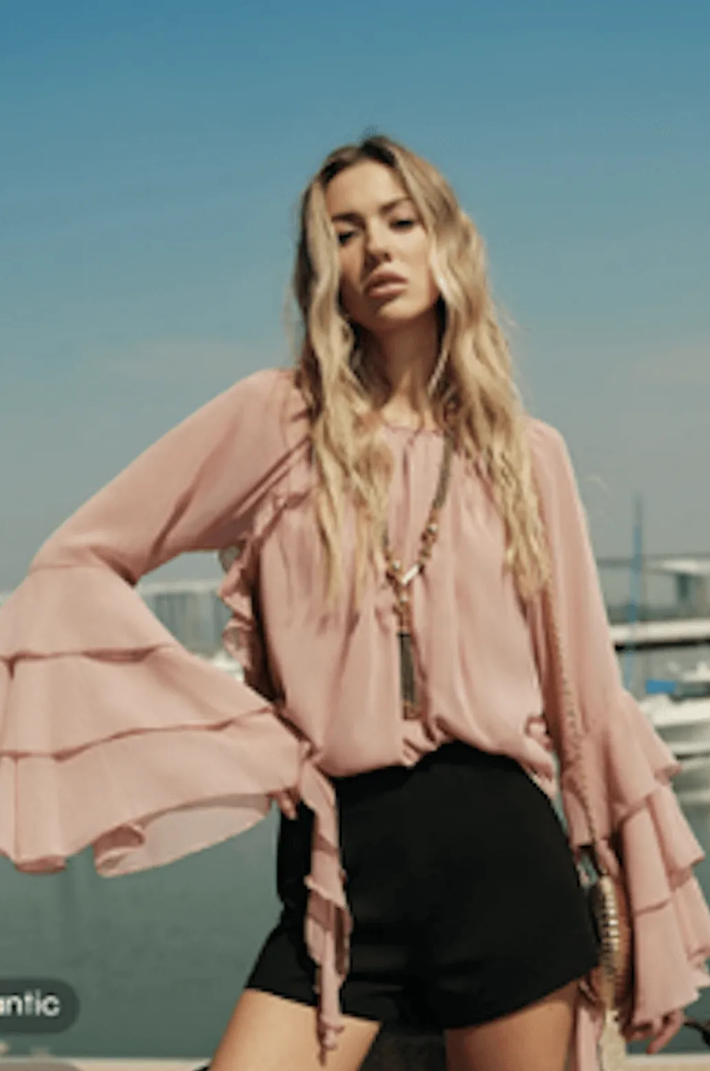 Model wearing a chiffon ruffle sleeve blouse in soft pink