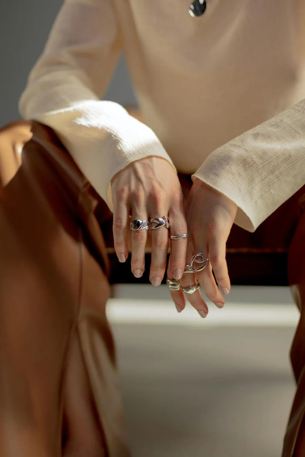 Chunky silver jewelry layered for a maximalist aesthetic