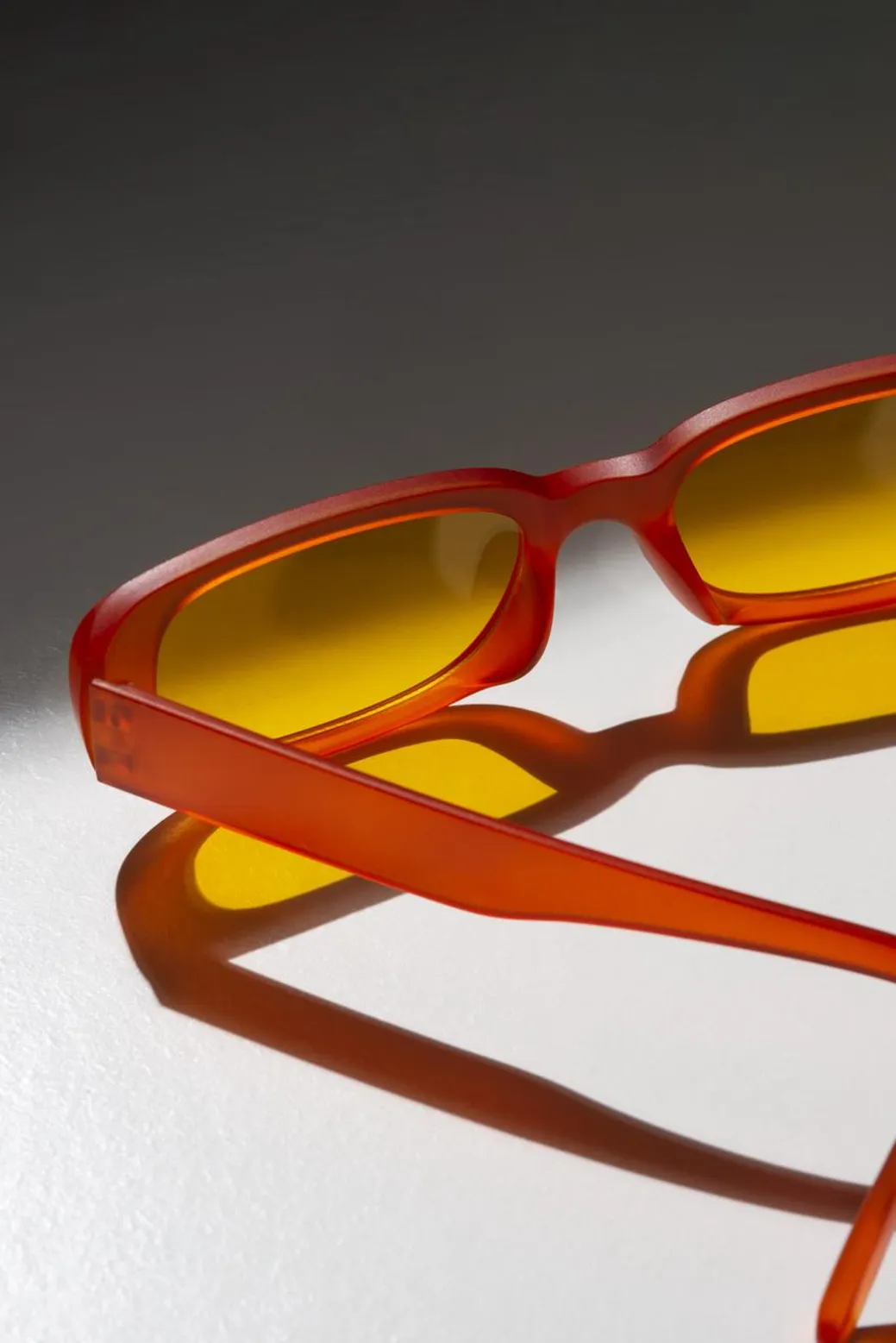 Retro orange-lensed glasses paired with slickback hair