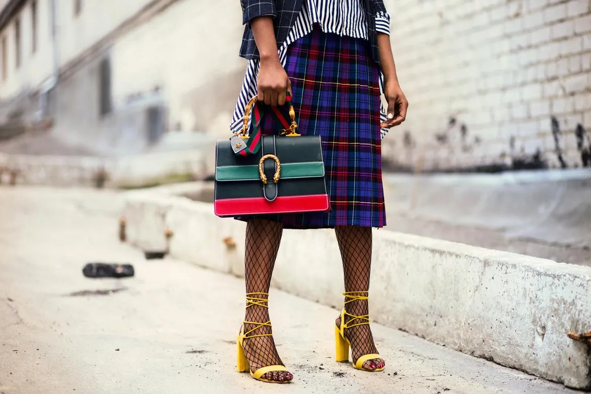 A bold and eclectic street style outfit featuring plaid, stripes, and statement accessories.